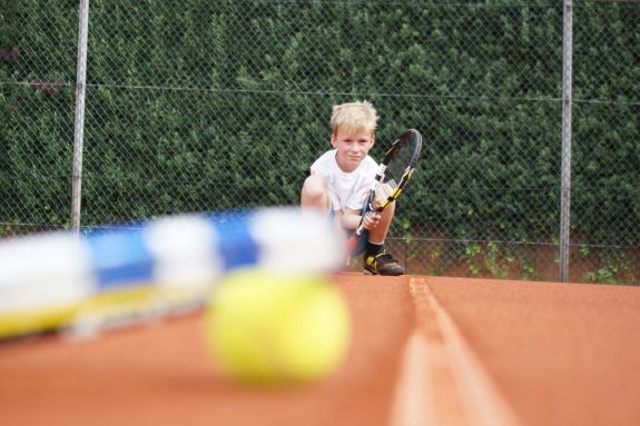 Junge auf dem Tennisplatz